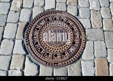 Gusseiserne Schachtdeckel mit Wappen der Stadt Dresden. Stockfoto