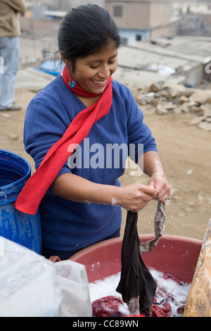 Eine junge Frau wäscht Kleidung von Hand in Lima, Peru, Südamerika. Stockfoto