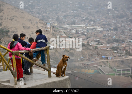 Kinder blicken über die Dächer von einem Vorort in Lima, Peru, Südamerika. Stockfoto