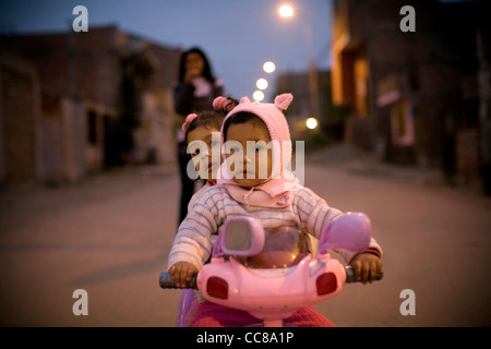 Kinder spielen auf dem kleinen Fahrrad in Villa El Salvador - Lima, Peru, Südamerika. Stockfoto