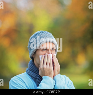 Mann bläst seine Nase in Seidenpapier wegen seiner Krankheit infiziert Stockfoto