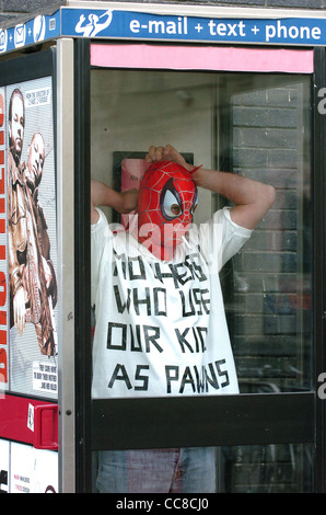 Der Demonstrator von Fathers for Justice passt seine Maske in einem Telefon an Box vor der Labour Party Konferenz in Brighton 2005 Großbritannien - Nur Für Redaktionelle Zwecke Stockfoto