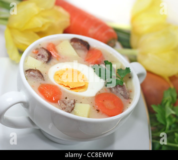 Traditionelle polnische weiße Borschtsch mit Eiern und Wurst in weißem Geschirr für Ostern Stockfoto