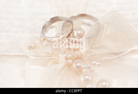 Paar goldene Hochzeit Ringe über Einladungskarte mit Seidenschleife & Perlen verziert Stockfoto