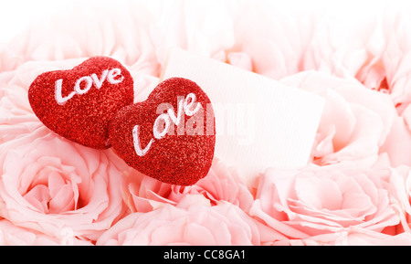 Leere Geschenkkarte mit roten Herzen isoliert auf rosa Rosen Hintergrund, Konzeptbild von Liebe & Valentinstag Urlaub Stockfoto