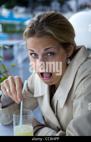 Eine Frau betäubt durch die Bitterkeit des Limoncello in Amalfi. Stockfoto