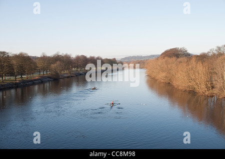 Blick nach Westen von der Brücke über den Fluss Tyne in Hexham, mit Ruderer training am Fluss unten. Hexham, UK. Stockfoto