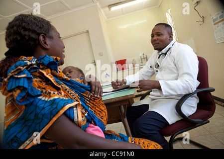 Eine Mutter berät sich mit einem Arzt in einer Klinik in Kitwe, Sambia, Südafrika. Stockfoto