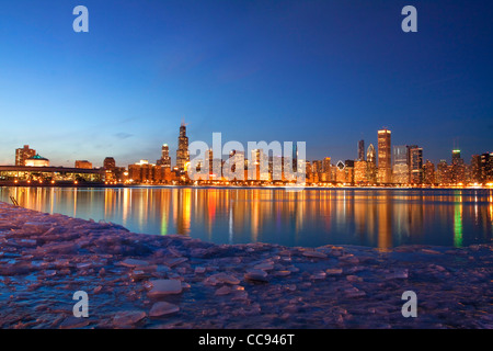 Skyline von Chicago in der Dämmerung im Winter mit einer Reflexion von Adler Planetarium gesehen. Stockfoto