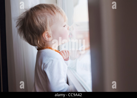 Porträt von Baby Mädchen suchen Fenster Stockfoto