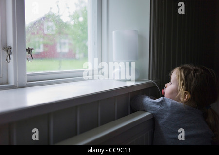 Junge Mädchen Blick aus Fenster, Schweden Stockfoto