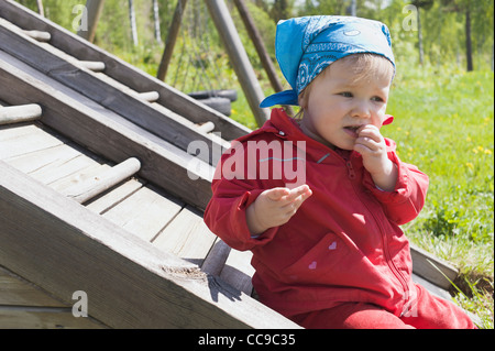 Babymädchen sitzen auf Spielplatz Stockfoto