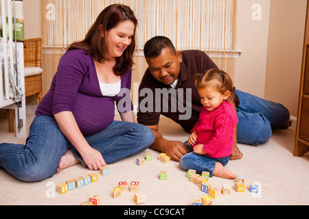 Familie sitzt am Boden spielen mit Bausteinen Stockfoto