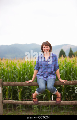 Porträt der Frau sitzt am Zaun, Sauvie Island, Oregon, USA Stockfoto