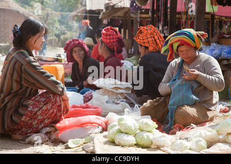 PA-O Indianerin in native Kostüm sitzen auf dem Markt verkaufen hausgemachte Speisen. Samkar, Inle-See, Shan-Staat, Burma. Stockfoto