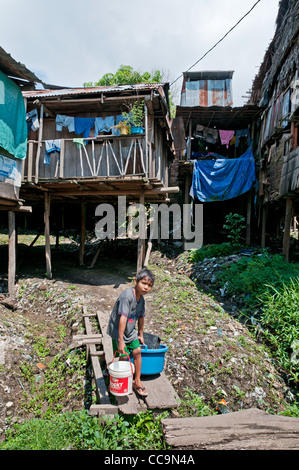 Iquitos, Peru. Kind mit Wasser und Wäsche Eimer in die Elendsviertel der Stadtteil Belen. Stockfoto