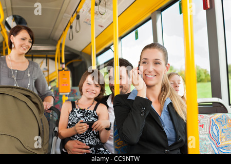 Passagiere im Bus - ein Pendler, eine Frau mit einem Kinderwagen, ein Mann Stockfoto