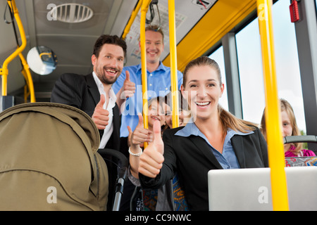 Passagiere im Bus - ein Pendler, ein Vater mit einem Kinderwagen, ein Mann, Kinder; alle mit thumps up Stockfoto