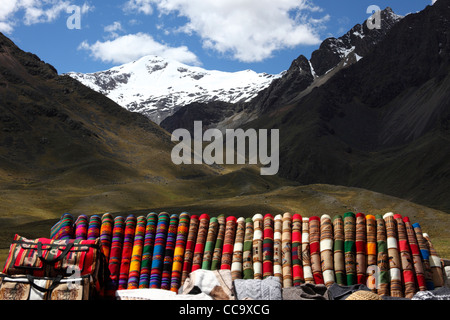 Textilstand am La Raya Pass neben der Bahn von Puno nach Cusco (verwendet von Orient Express-Zügen), im Hintergrund Mt Chimboya, Peru Stockfoto