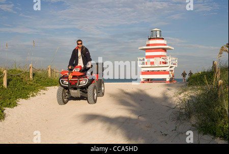 Ein Rettungsschwimmer fahren einen Dünen-Buggy auf South Beach Miami mit eine Strandwache im Hintergrund Stockfoto
