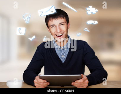 Ein Geschäftsmann mit Symbole schwimmende rund um seinen Kopf. Porträt von hübschen Kerl arbeitet mit seinem TabletPC, Blick in die Kamera und Stockfoto