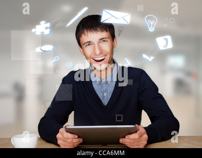 Ein Geschäftsmann mit Symbole schwimmende rund um seinen Kopf. Porträt von hübschen Kerl arbeitet mit seinem TabletPC, Blick in die Kamera und Stockfoto