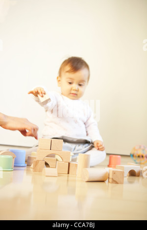 Tochter spielen mit Spielzeug Bausteine, die Mutter von Hand auf Stockfoto