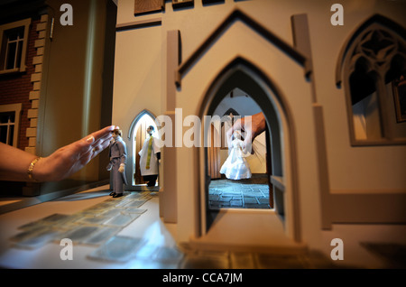 Ein Pfarrer von Woodside Puppen mit dem Bräutigam vor einer Hochzeitsszene in "All Saints Church" von Barbaras Formteile bei "Miniatura" Stockfoto