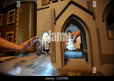 Ein Pfarrer von Woodside Puppen mit dem Bräutigam vor einer Hochzeitsszene in "All Saints Church" von Barbaras Formteile bei "Miniatura" Stockfoto