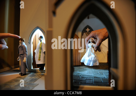 Ein Pfarrer von Woodside Puppen mit dem Bräutigam vor einer Hochzeitsszene in "All Saints Church" von Barbaras Formteile bei "Miniatura" Stockfoto