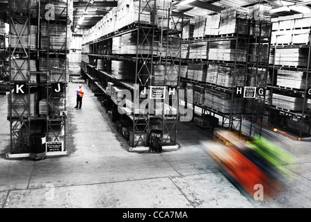 Ein Mann und einem Gabelstapler arbeiten in einer Industriehalle. Stockfoto