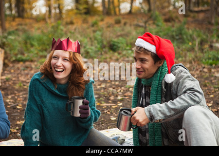 Junges Paar tragen Santa Hüte und Kronen im Wald Stockfoto