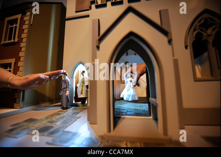 Ein Pfarrer von Woodside Puppen mit dem Bräutigam vor einer Hochzeitsszene in "All Saints Church" von Barbaras Formteile bei "Miniatura" Stockfoto