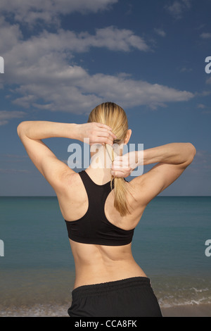 Mitte erwachsenen Frau Pferdeschwanz binden Rückansicht Stockfoto
