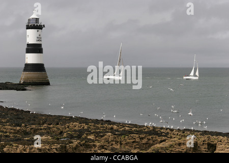 Beiden Rennyachten vorbei Trwyn Du Leuchtturm am Penmon, Anglesey, North Wales, UK Stockfoto