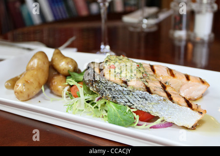 Gebratene Linie gefangen schottischem Lachs, serviert mit frischen Kartoffeln, Knoblauch & Pfeffer Butter und Salat Beilage Stockfoto