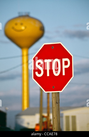 Gelbe "Smiley-Gesicht" Wasserturm und Stop-Schild, Adair, Iowa, USA'' gelber '' Smiley-Gesicht '' Wasserturm und Stop-Schild, Adair Stockfoto