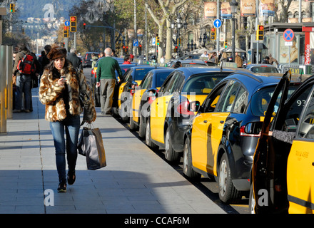Barcelona, Spanien. Taxis. Frau zu Fuß vorbei an SMS auf Handy Stockfoto