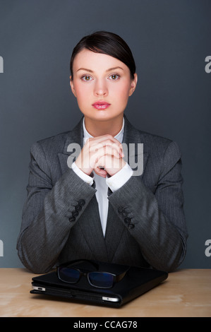 Portrait von junge hübsche Frau mit Brille und Touch-Pad-Computer in ihrem Büro sitzen Stockfoto