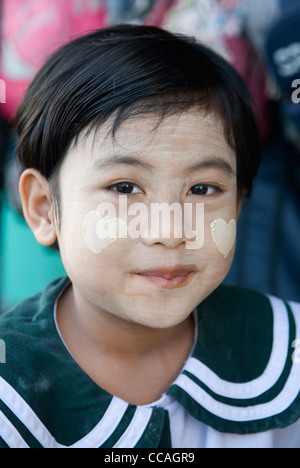 Kind in Schuluniform tragen Make-up Thanakha. Ein natürliches Produkt. Zwei Herzen auf jede Wange. Pathein Burma Myanmar. Stockfoto