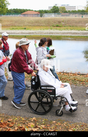 Älterer Mann mit Frau im Rollstuhl bei Alzheimer Speicher gehen, Old River Park, Dayton, Ohio, USA. 26. September 2010. Stockfoto