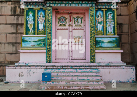 Bunt bemalte Schrein mit einer Spendenbox davor Rangaji Mandir, Vrindavan, Indien Stockfoto