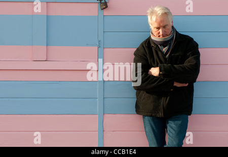 deprimiert senior männlich stützte sich auf Strandhütte Stockfoto