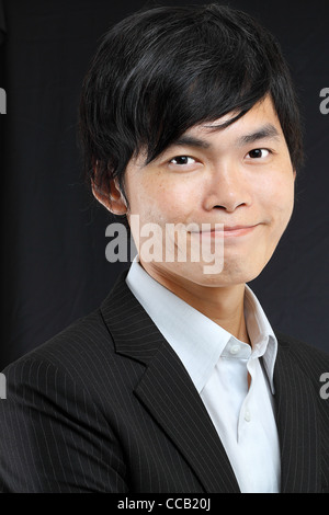 Junge asiatische Mann im schwarzen Anzug Stockfoto