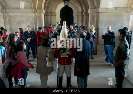 Touristen posiert neben einem Household Cavalry, Life Guards Regiment, Horse Guards Parade, London, England Stockfoto