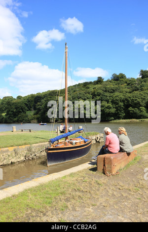 Ein Segelboot auf dem Fluss Tamar am Cotehele Quay in Cornwall unter Cotehele House. Stockfoto