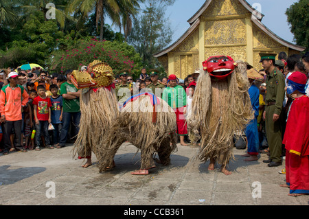 Mythische maskierten Figuren tanzen vor goldenen Sim an Wat Xieng Thong auf Mue Nau, Luang Prabang, Laos Stockfoto