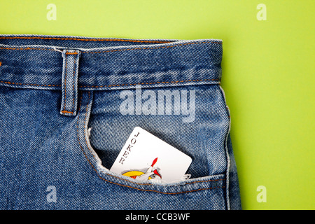 Joker Spielkarte in Blue Jeans-Tasche mit grünem Hintergrund Stockfoto