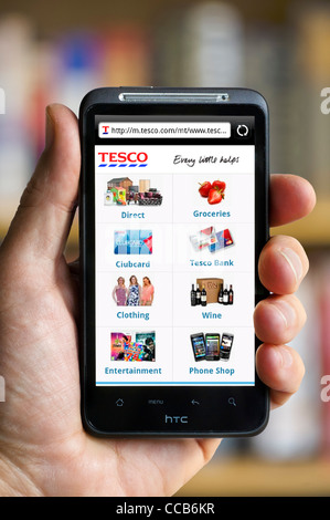 Online-Shopping bei Tesco auf einem HTC-smartphone Stockfoto