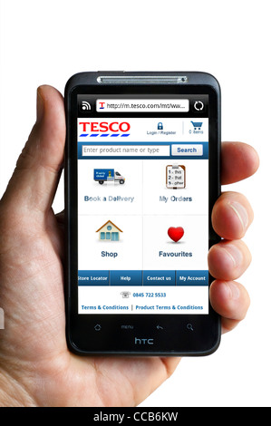 Online-Shopping bei Tesco auf einem HTC-smartphone Stockfoto